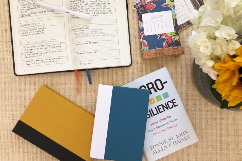 books on a table with a calendar and a flower arrangement
