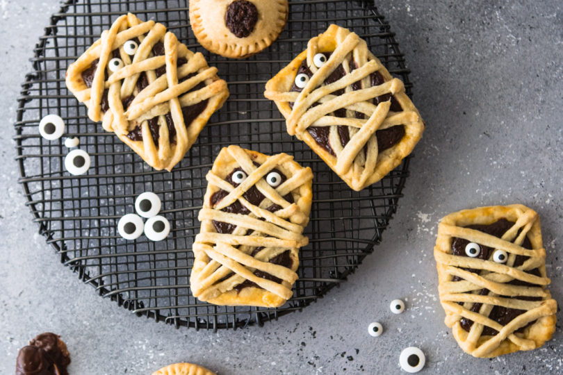 Chocolate filled hand pies on a black baking rack against a gray backdrop