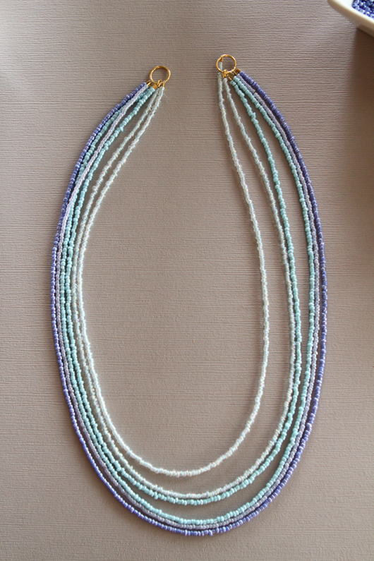 6 strands of seed beads strung together into an blue ombre necklace