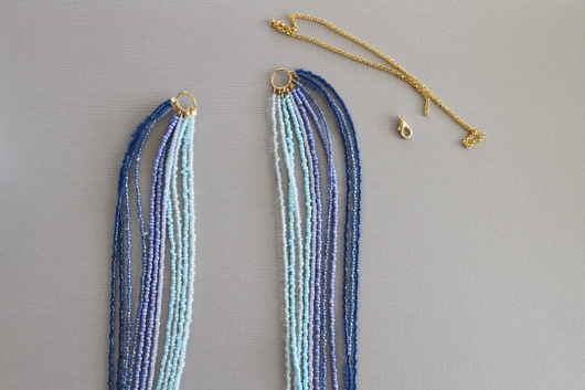 ombre blue seed bead necklace with a gold chain and clasp to the side