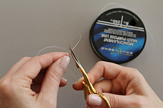 cutting the necklace string with gold scissors 