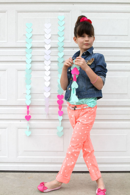 heart garlands taped on garage door next to brunette girl