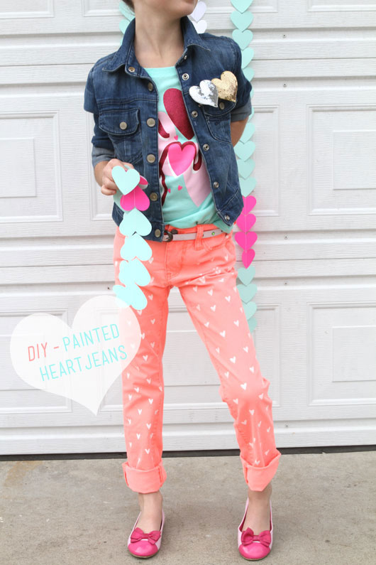 little girl standing in front of garage with heart jeans