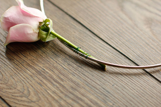 pink rose attached to a metal hoop with floral wire