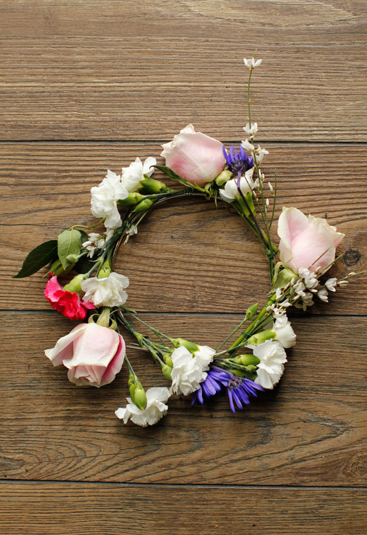 small round metal hoop covered in various colored carnations and roses