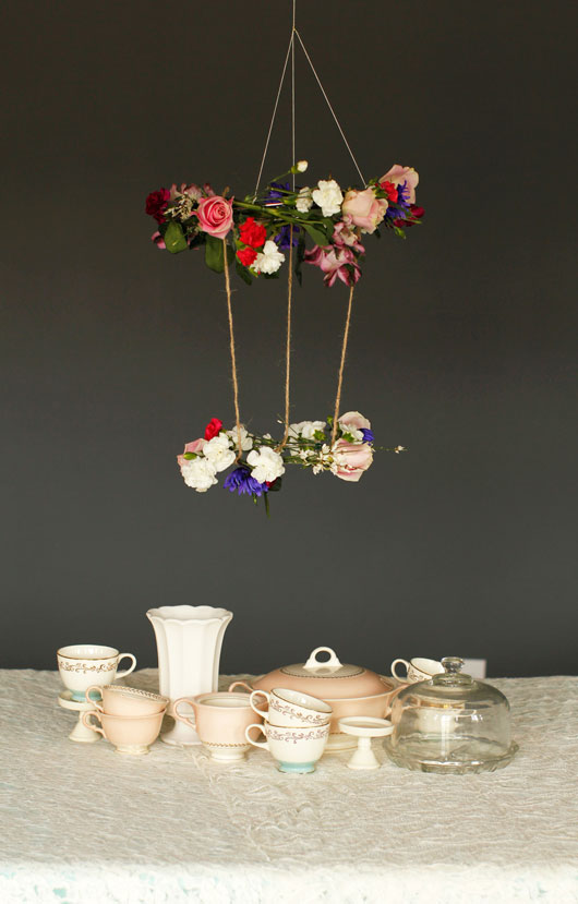 DIY hanging floral chandelier above a table set for tea