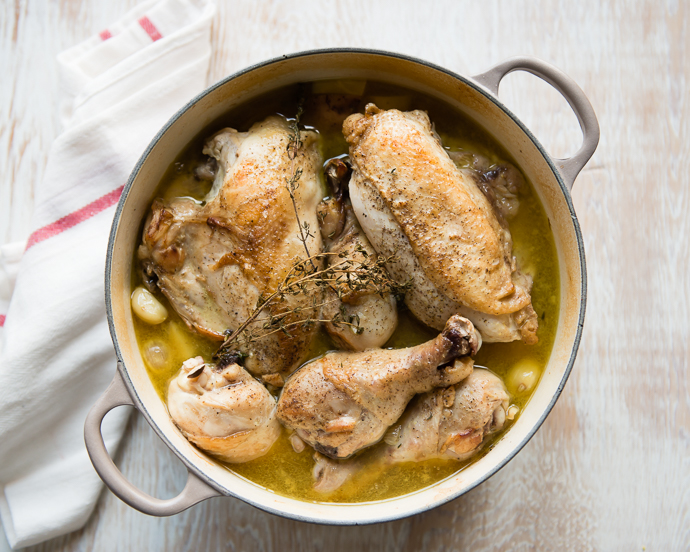 one pan roasted chicken and potatoes in a Dutch oven on a wooden board