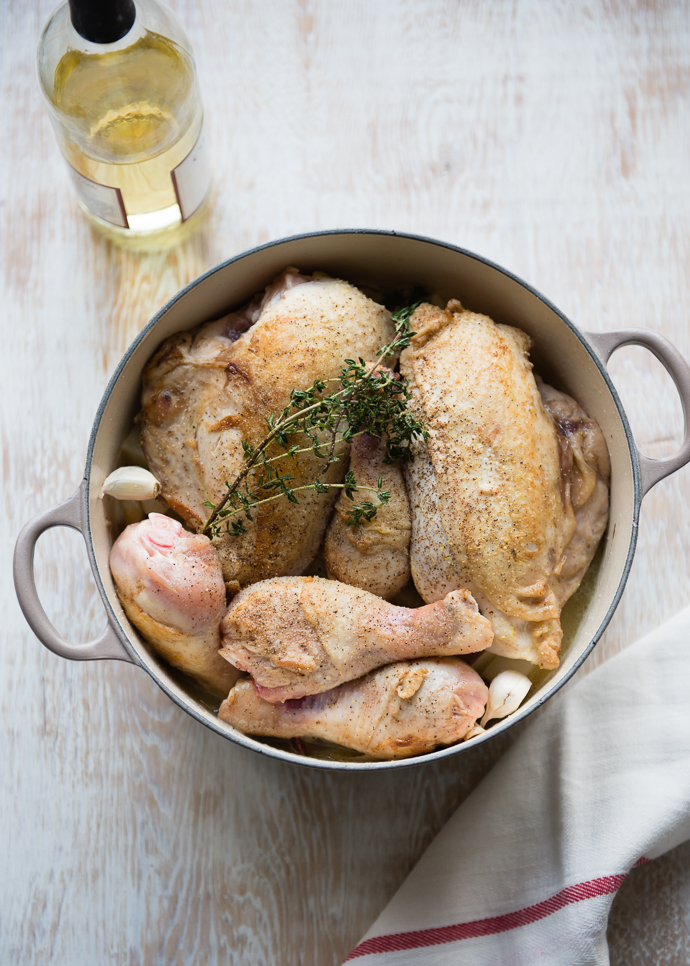 chicken and potatoes about to go in the oven for cooking set on a wooden board