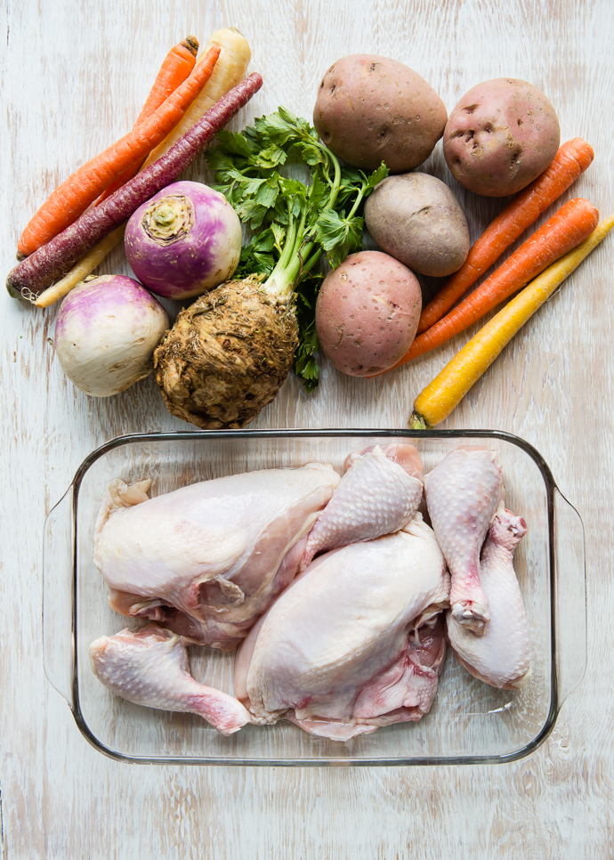 raw chicken and veggies on a board ready to make one pan roasted chicken and potatoes