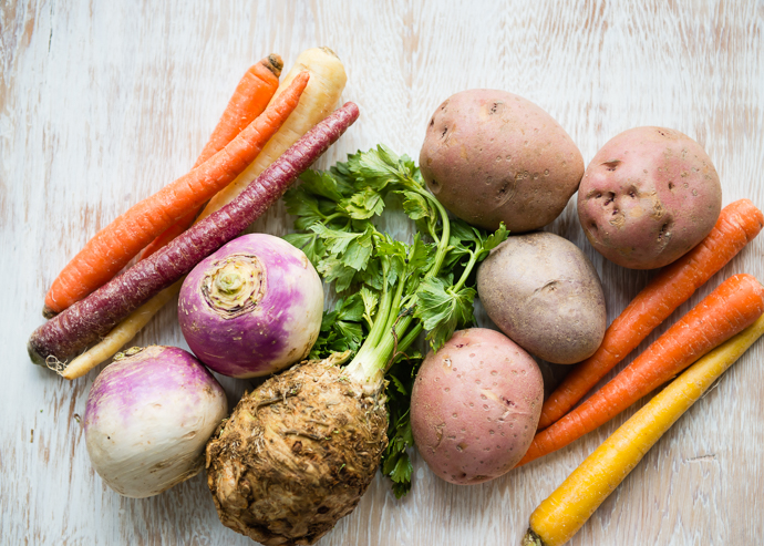 root vegetables and potatoes and carrots on a wooden board