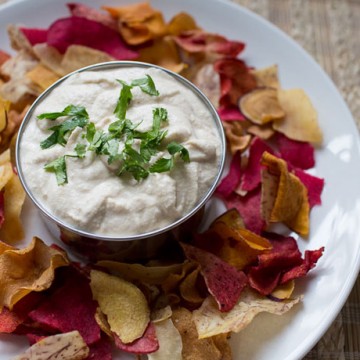 bowl of cashew cream dip surrounded by veggie chips