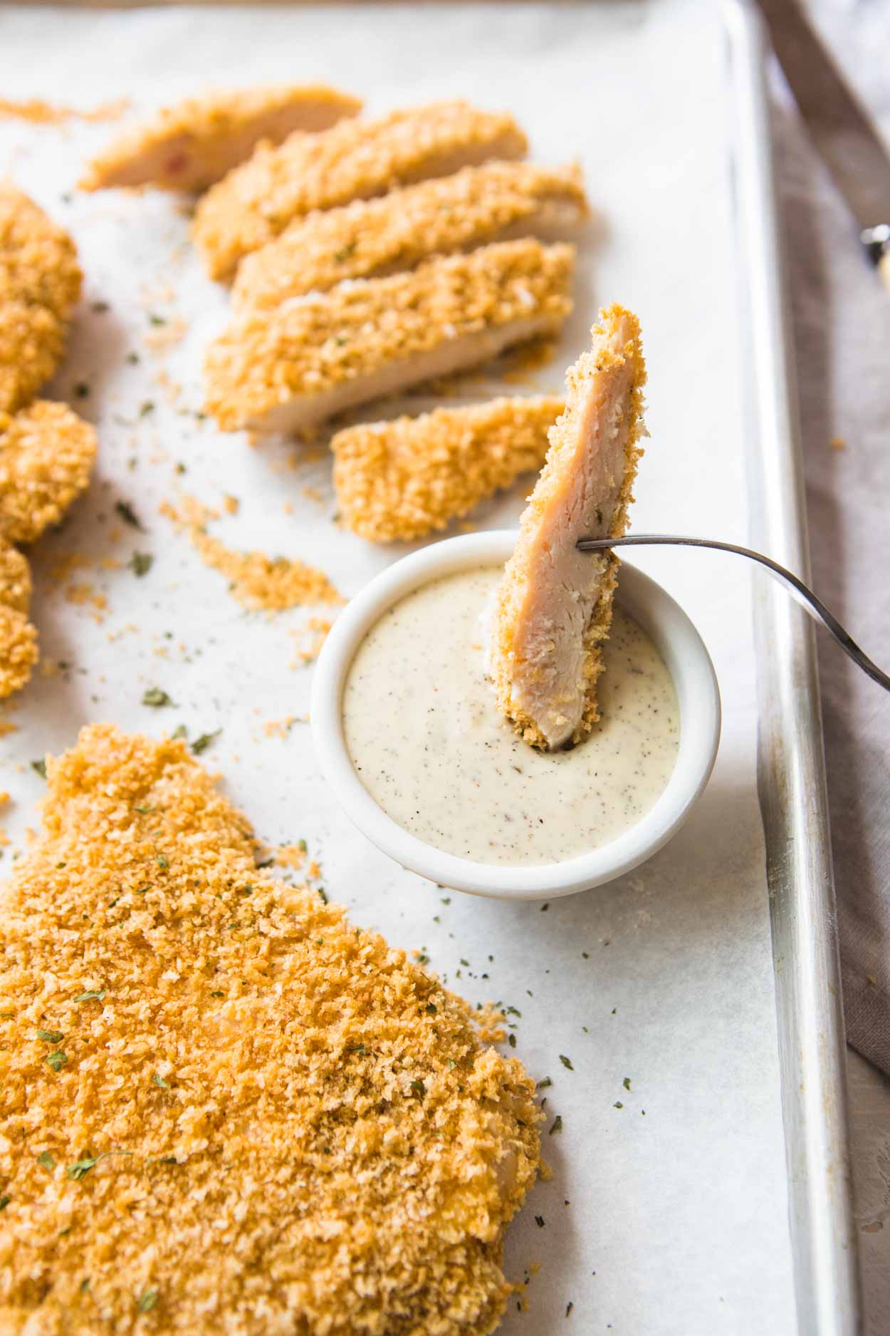 chicken breast coated in breadcrumbs and baked cut up and dipped into ranch dressing