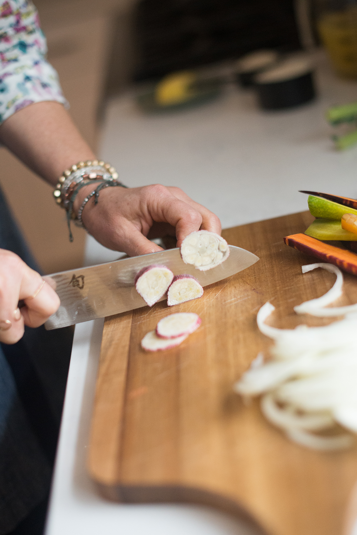 cutting green garlic on a wooden cutting board