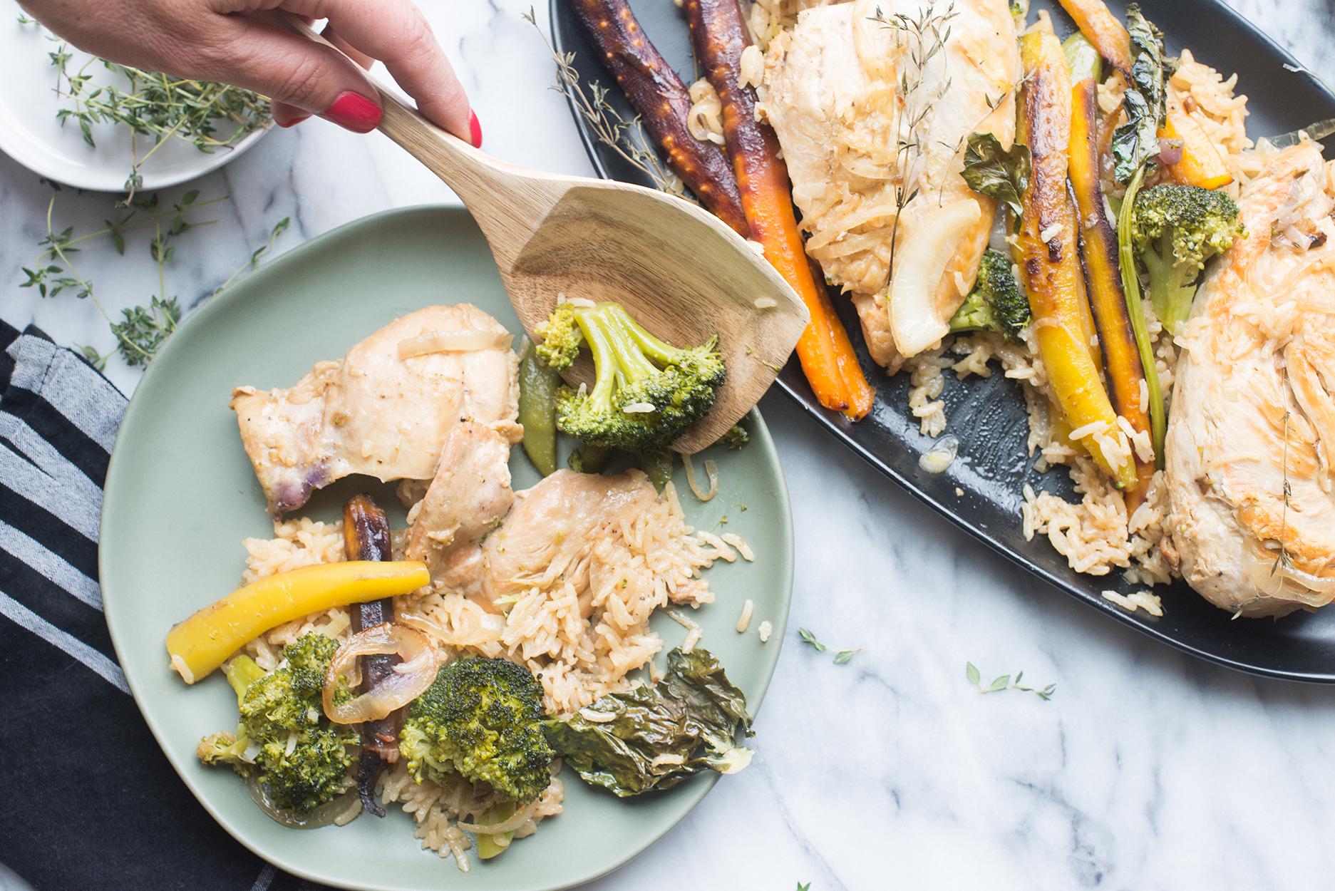 chicken, vegetables and rice being served with a wooden spoon onto a blue plate.