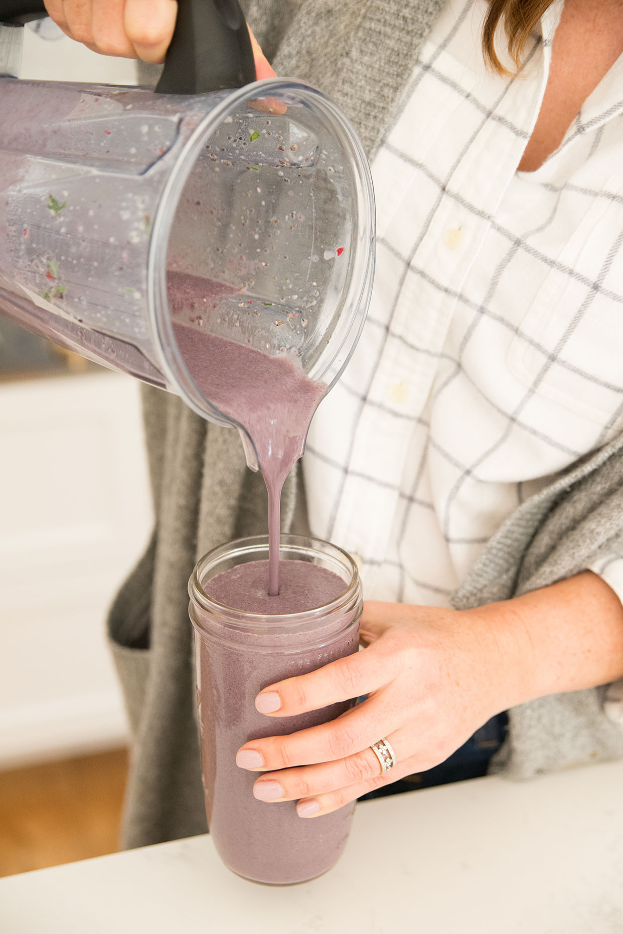 andrea pouring a purple smoothie into a glass