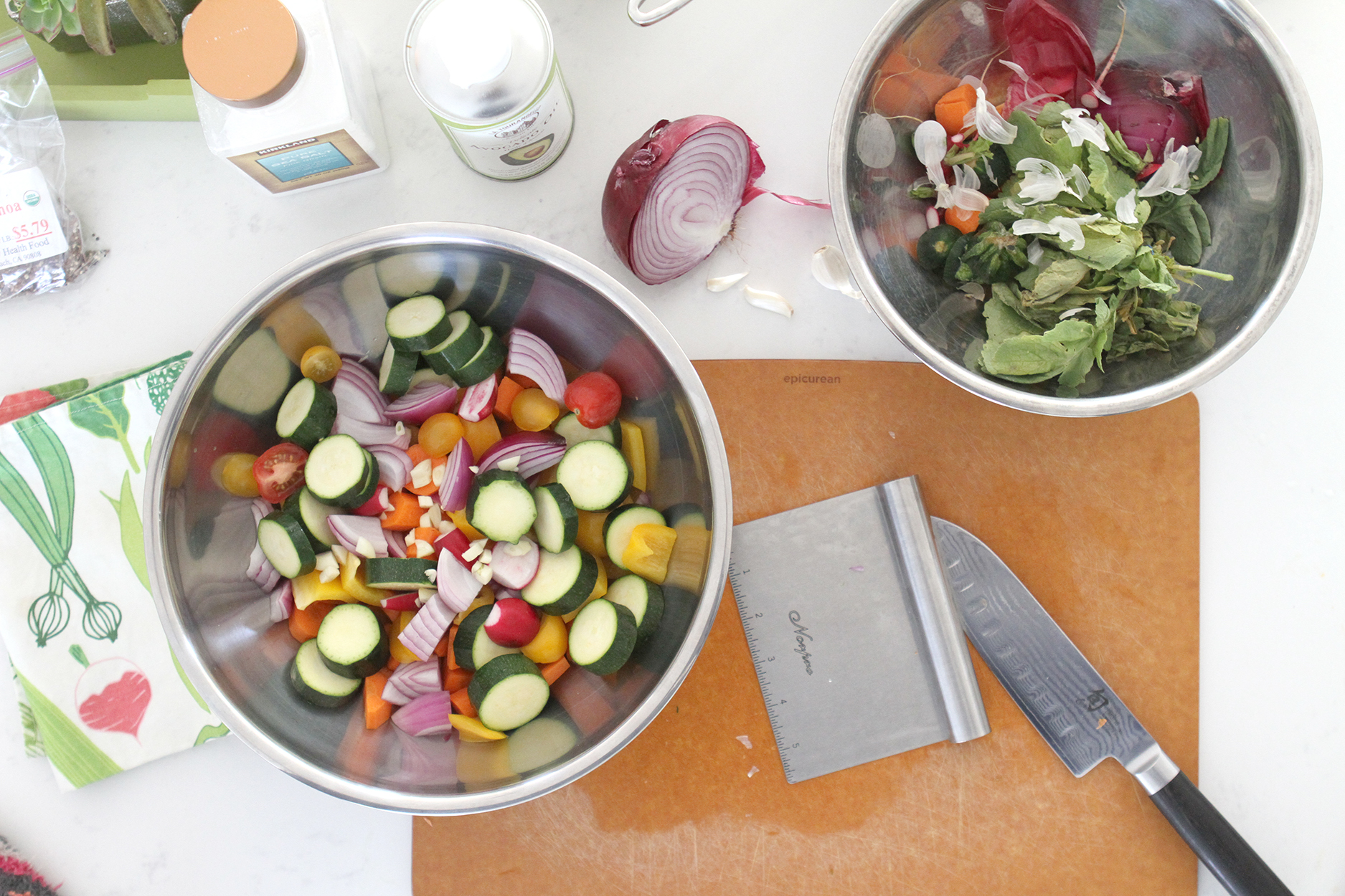 a cutting board, a stainless steel bowl of cut veggies