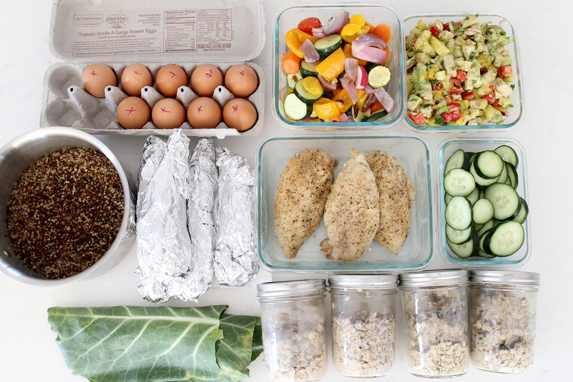 meal prep with hard boiled eggs, sauteed veggies, kale, chicken, cucumbers and chia seeds