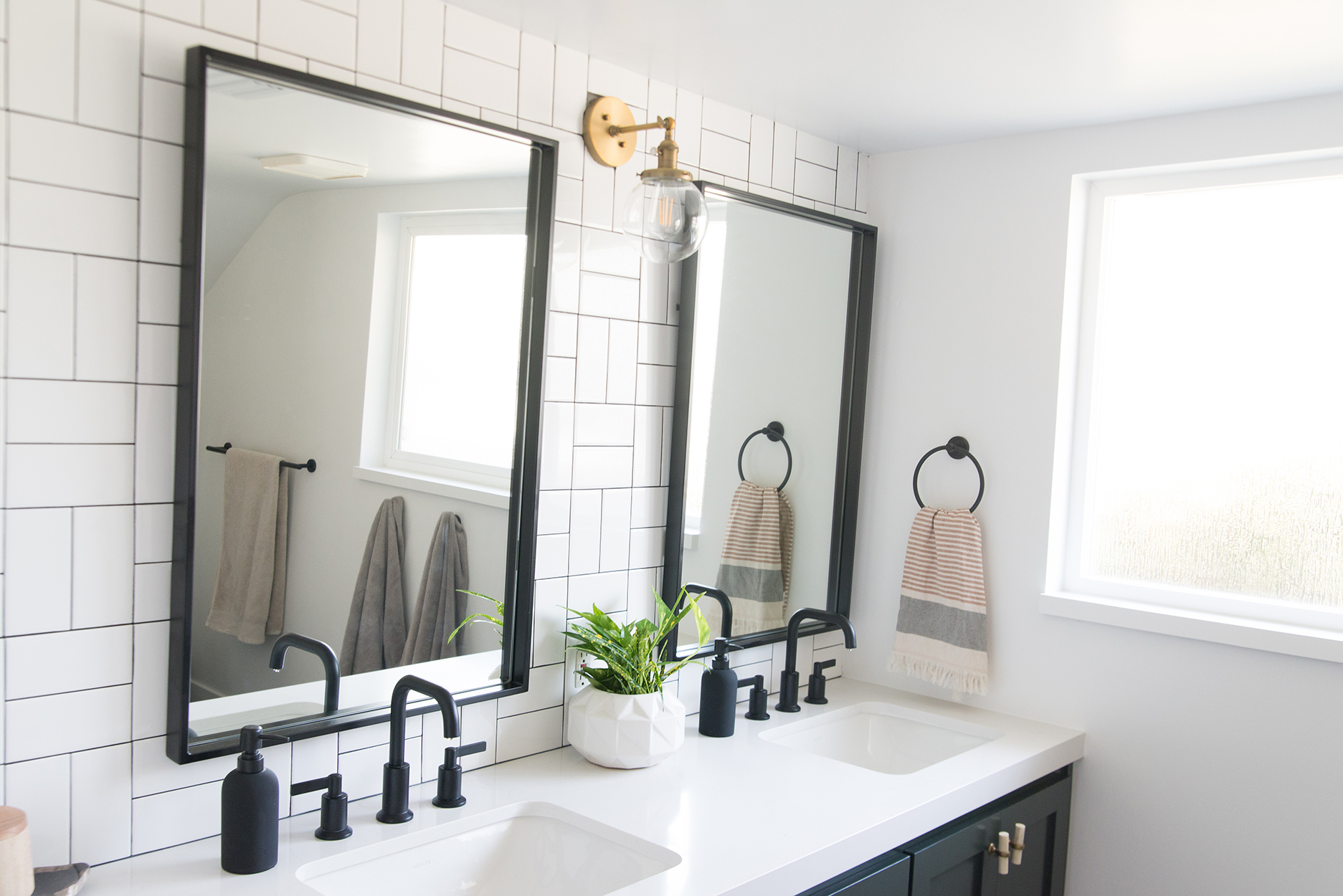 Bathroom mirrors with a white vanity counter top and black fixtures