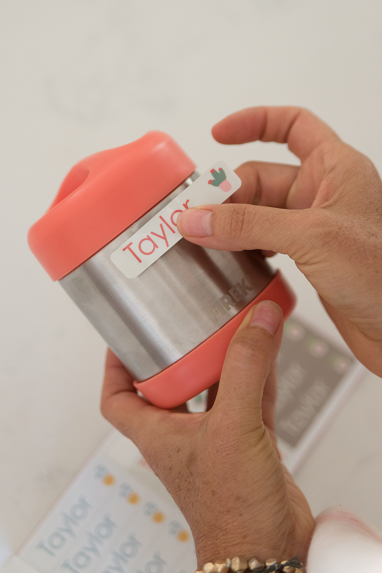 putting a name sticker on the lunch thermos