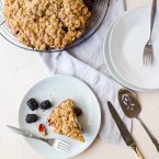 Slice of Blackberry Cake on a gray plate with a fork on a white background