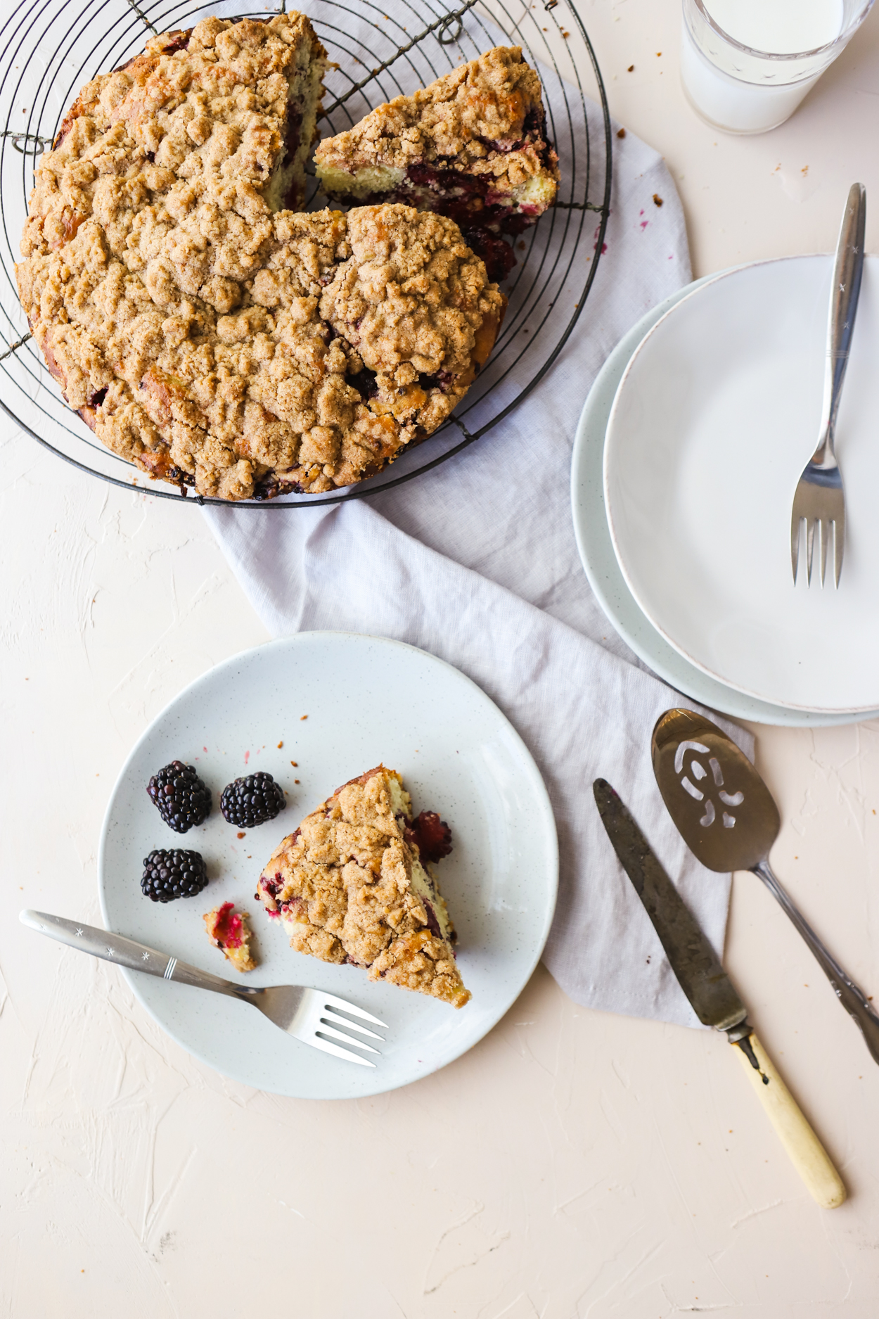 Slice of Blackberry Cake on a gray plate with a fork on a white background 