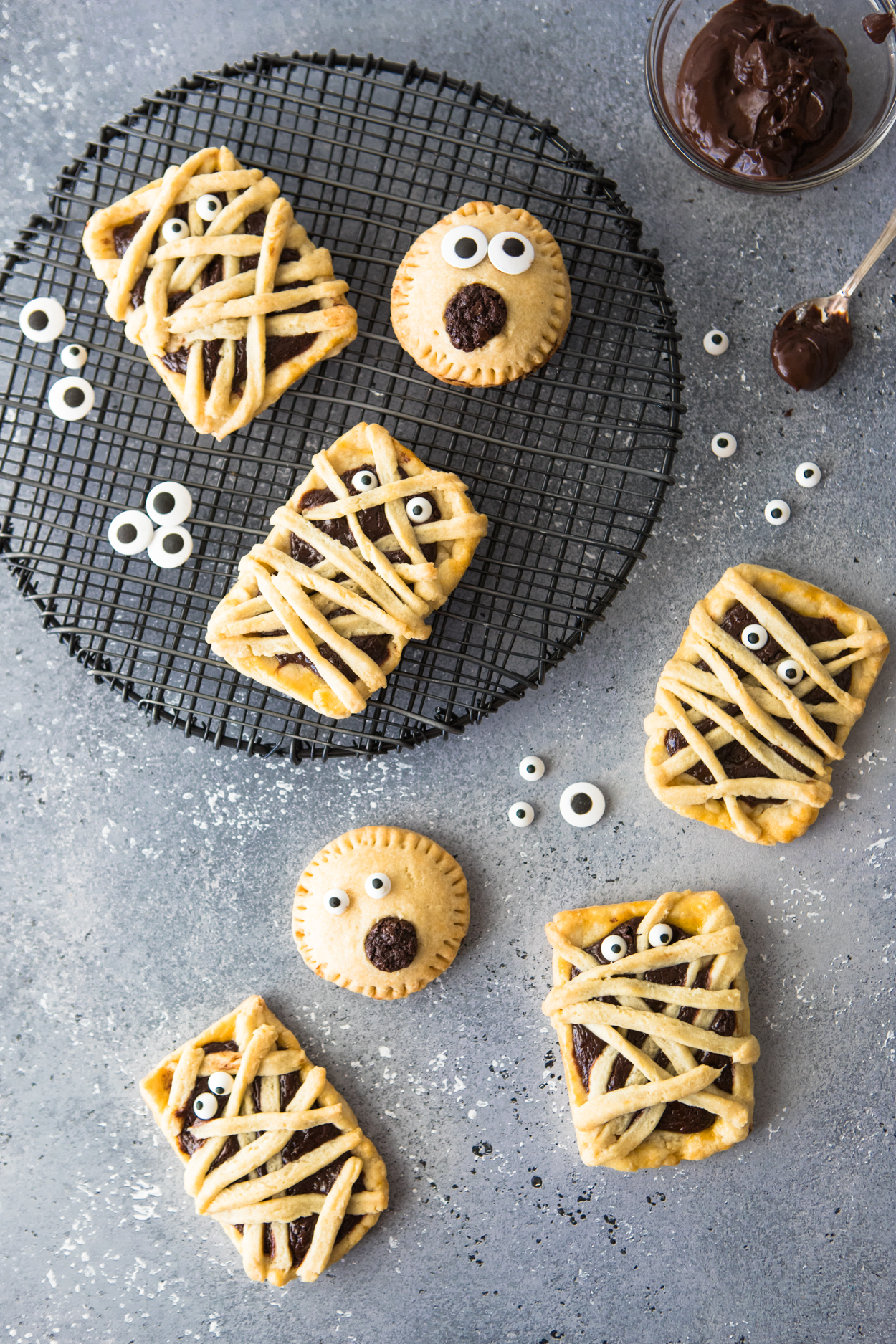 Chocolate filled hand pies on a black baking rack against a gray backdrop 