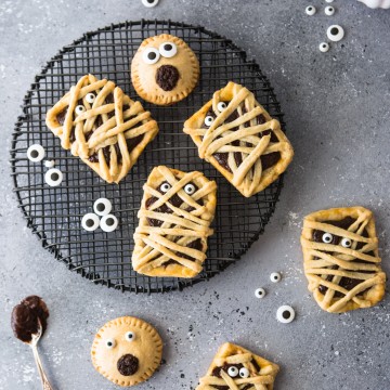 Chocolate filled hand pies on a black baking rack against a gray backdrop