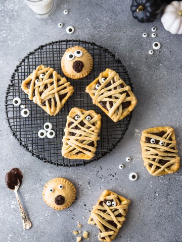 Chocolate filled hand pies on a black baking rack against a gray backdrop