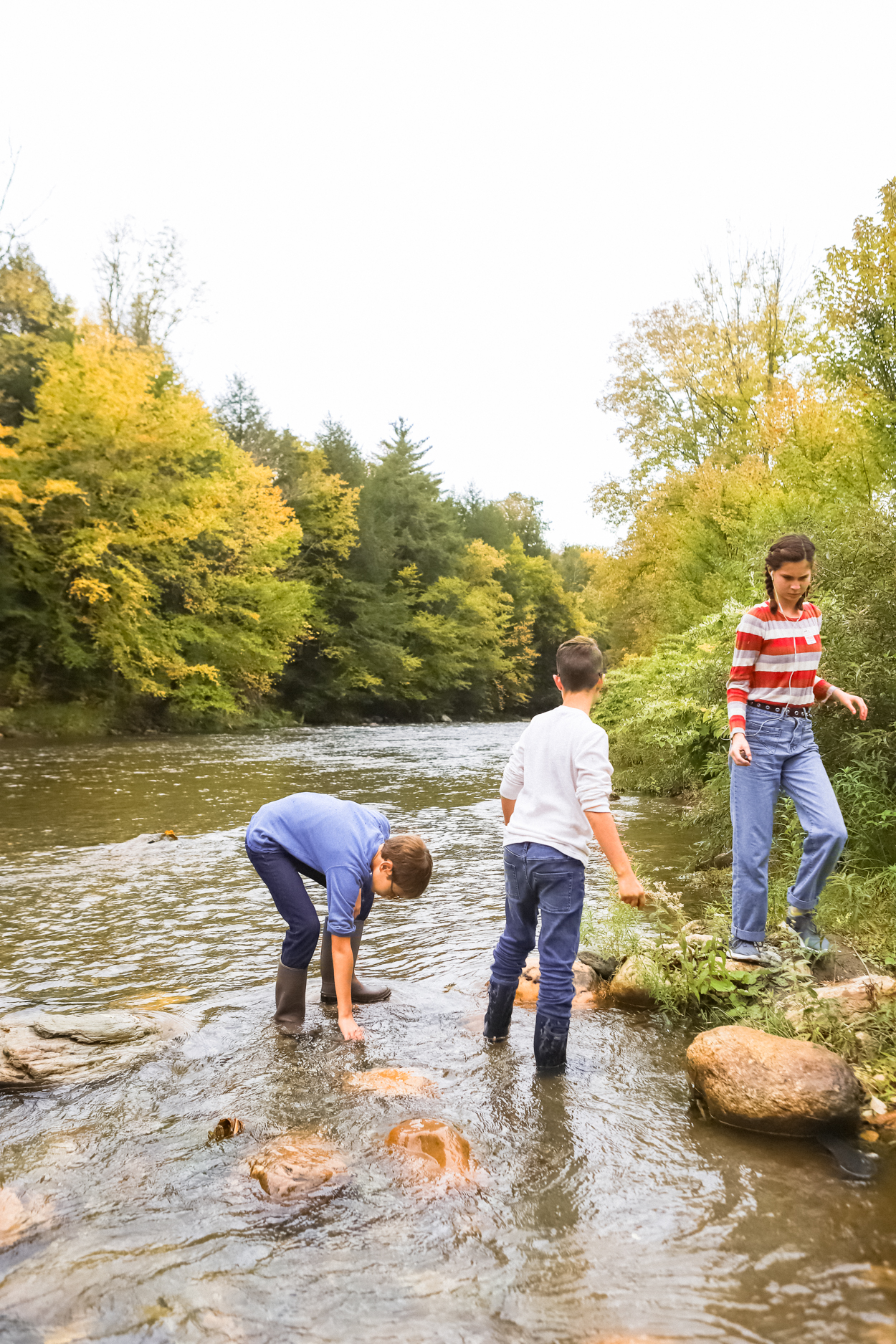 Kids playing in Ottauquechee River during the Fall in Vermont