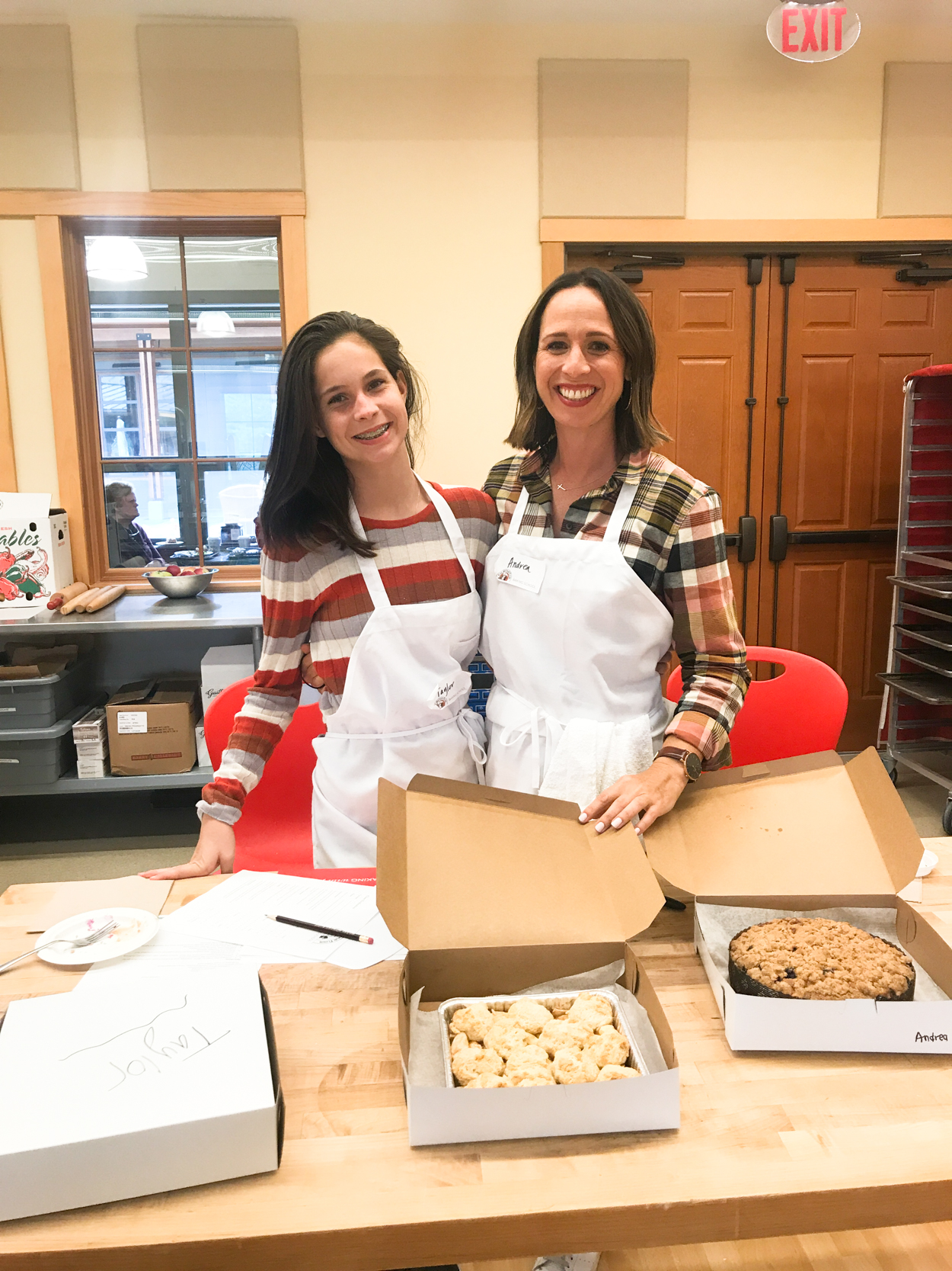 Mom and daughter wearing aprons standing in baking school at King Arthur Flour Baking School