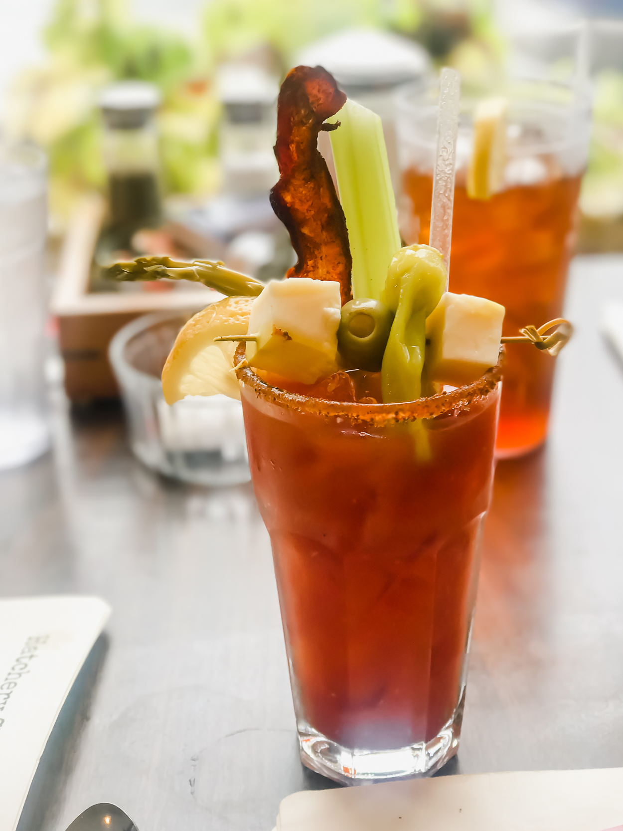 Bloody Mary Drink with bacon, asparagus, olive and cheese garnish on a table at Hatchery Restaurant in Ludlow Vermont