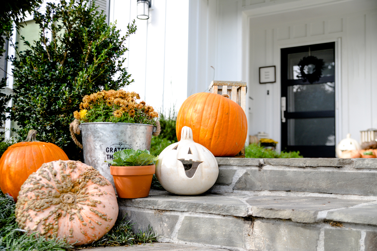 Decorate orange pumpkins and mums in a zinc tin and ornamental cabbage on a slate porch with steps