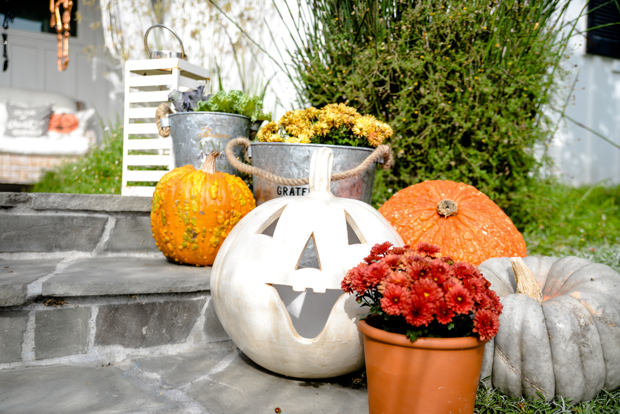 Decorate orange pumpkins and mums in a zinc tin and ornamental cabbage on a slate porch with steps