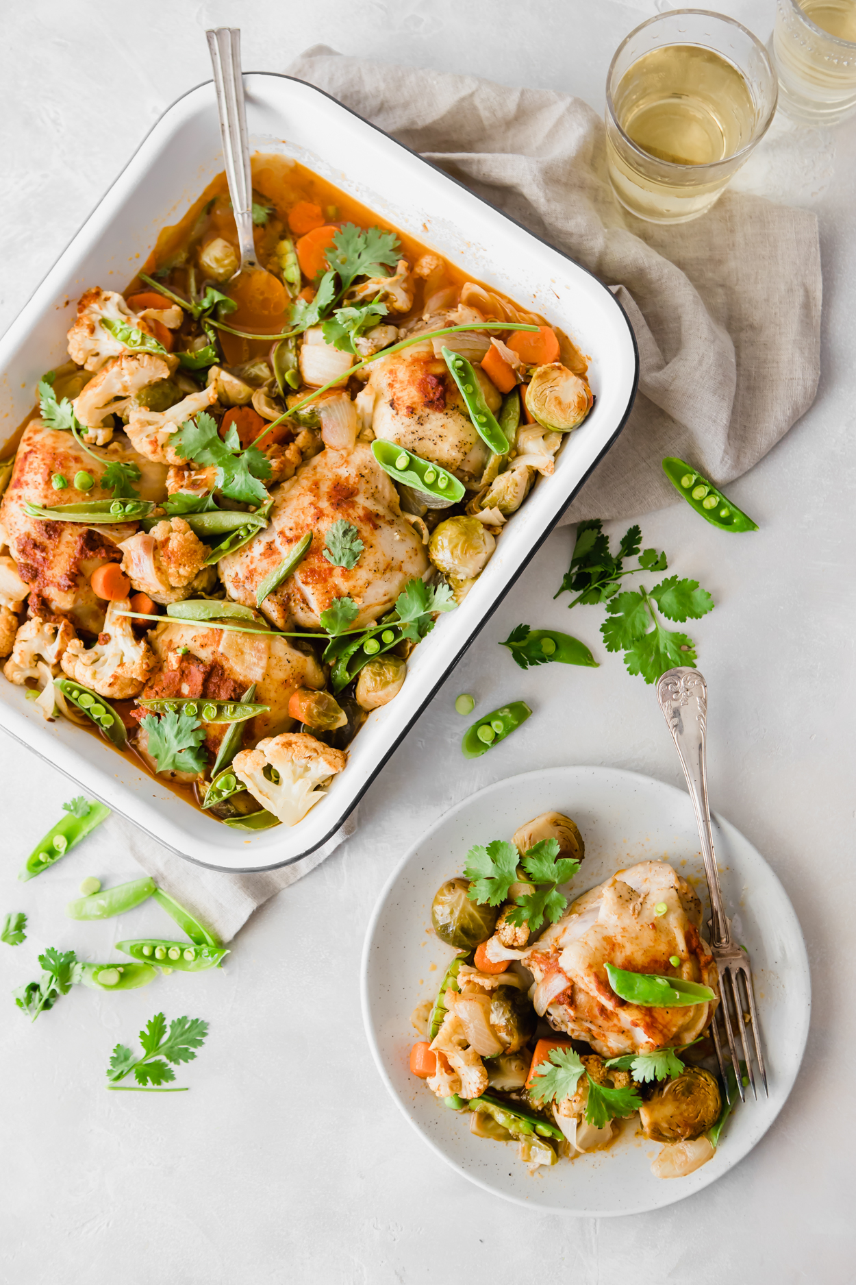 Coconut Thai Curry Chicken and veggies in a white baking dish and on a white plate