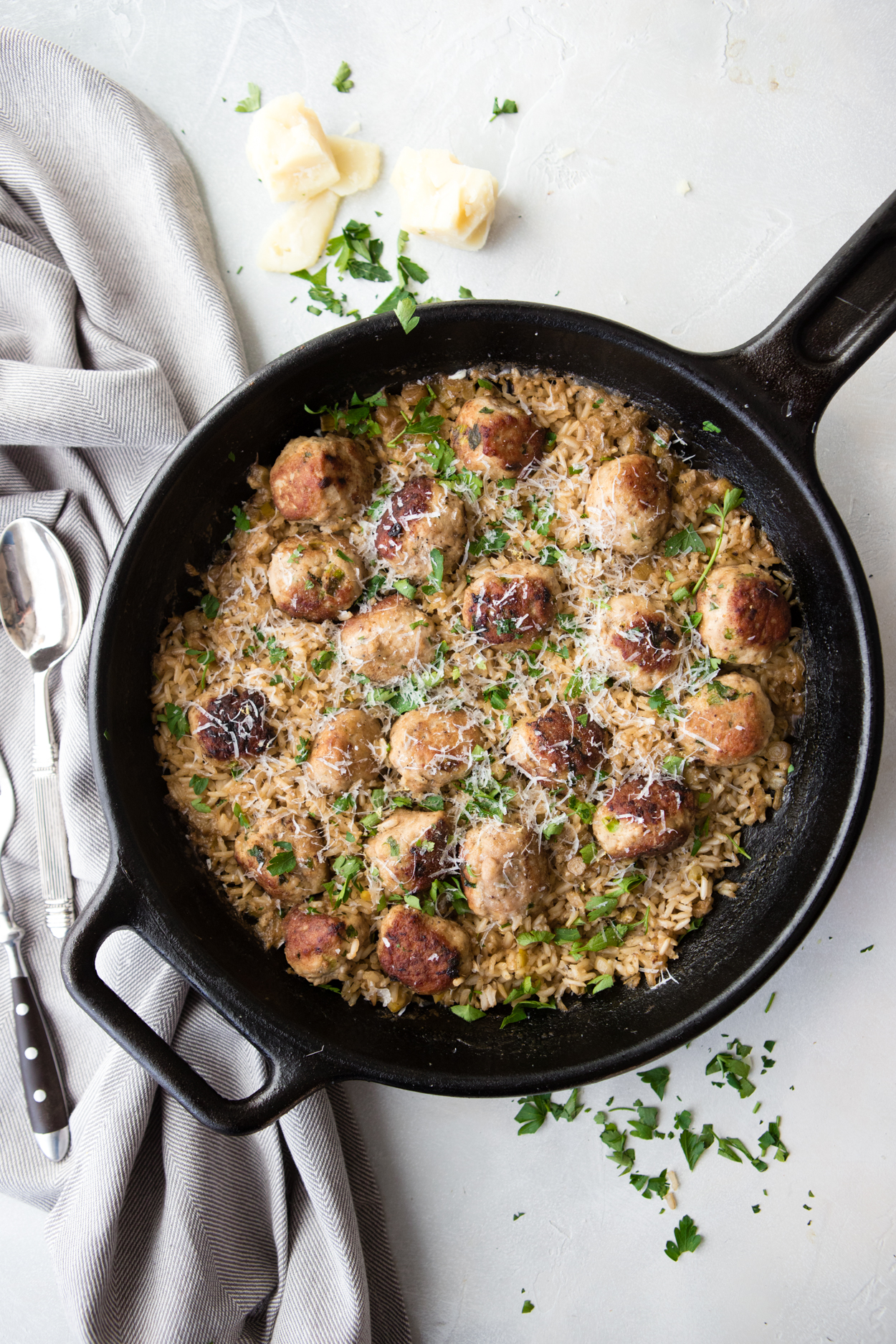 turkey meatballs and rice in a cast iron skillet on a white background 