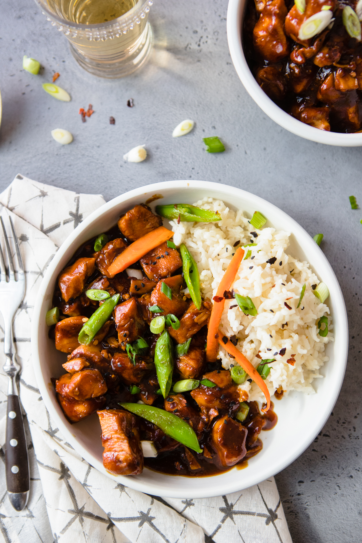  Instant Pot General Tso's Chicken with Rice in a white bowl sitting on a napking with a fork