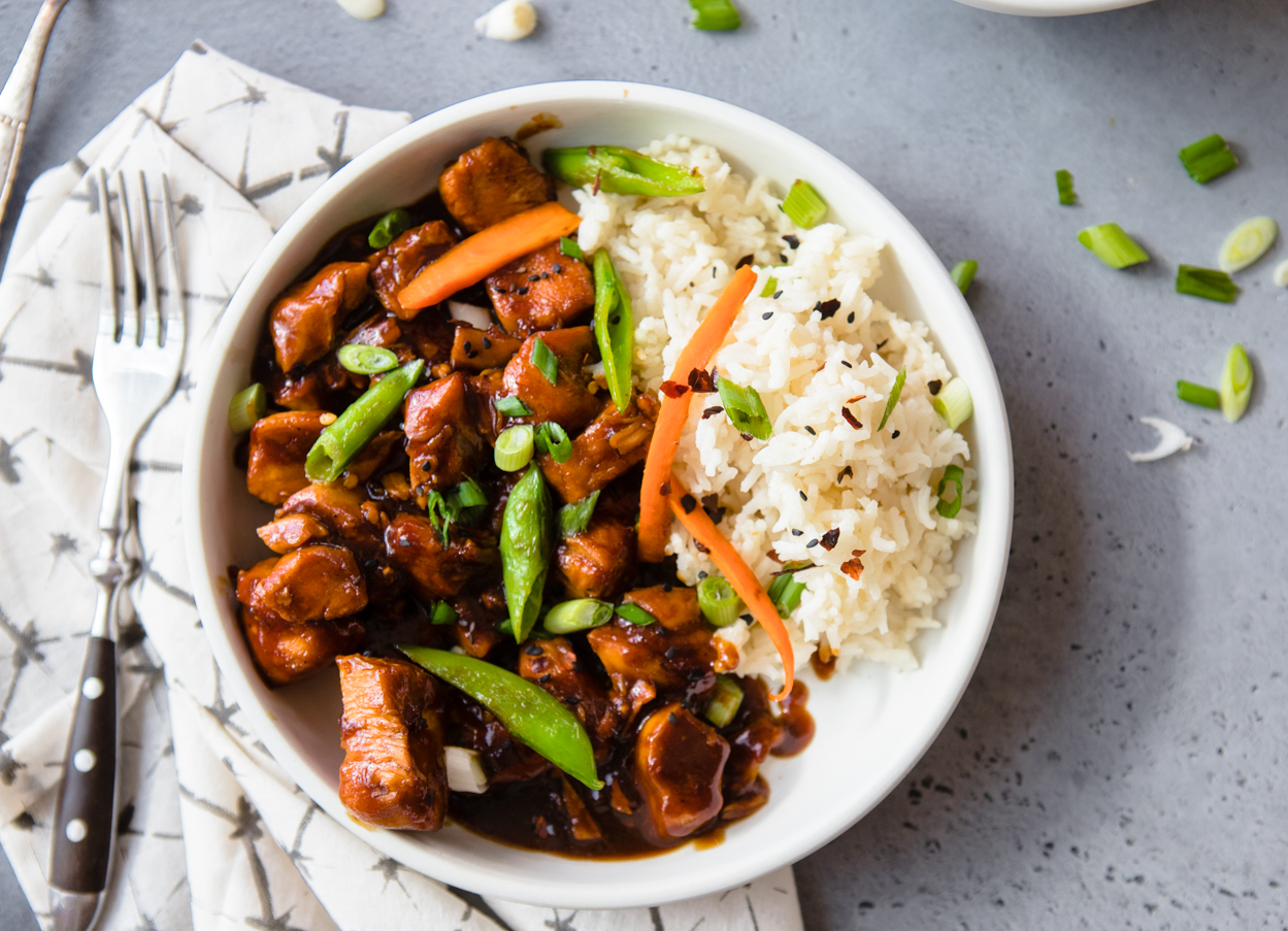 homemade General Tso's Chicken with rice in a white bowl