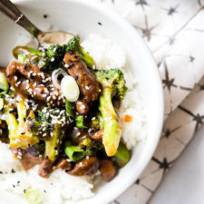 Instant Pot beef and broccoli in a white bowl over rice