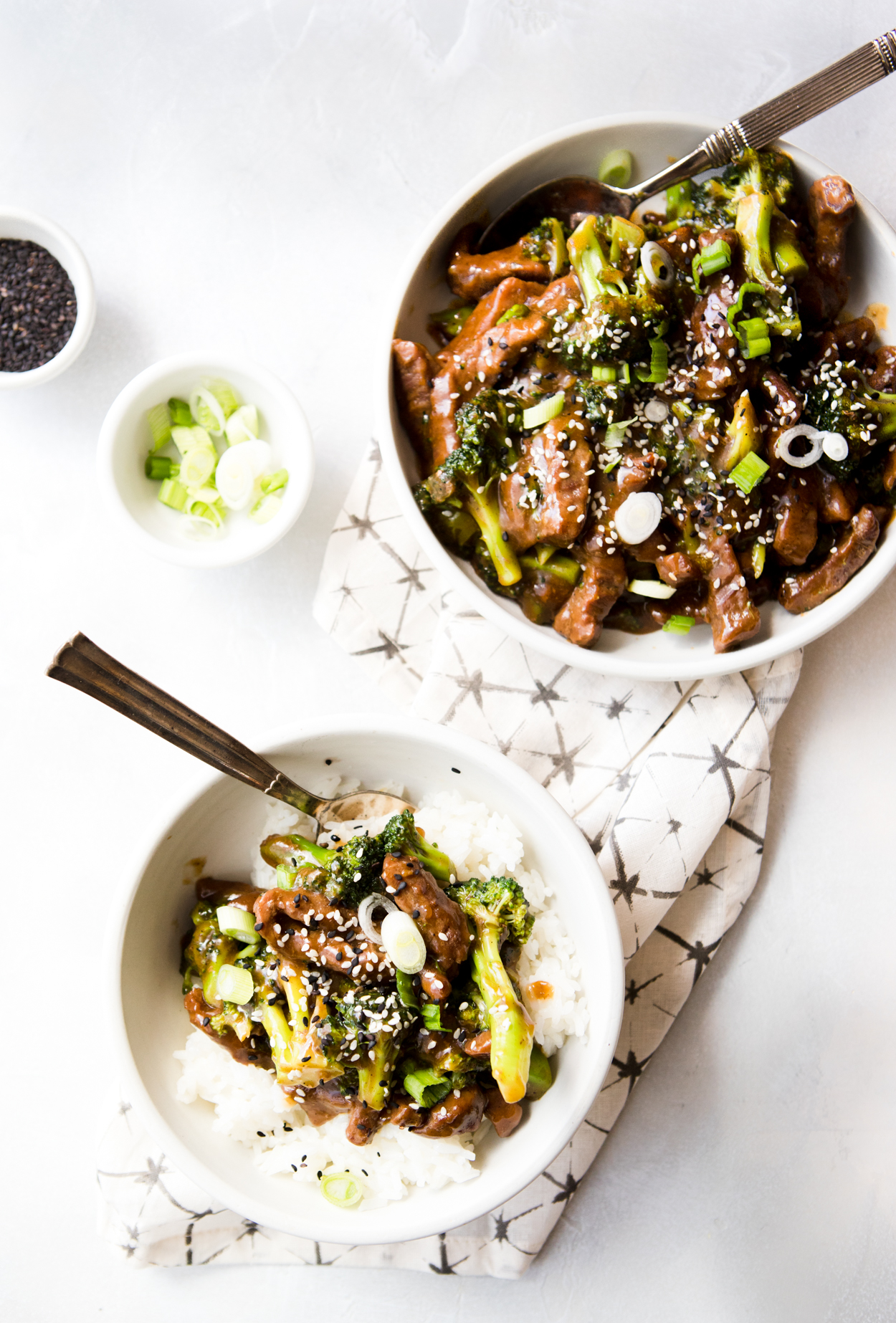 chinese takeout copycat, beef and broccoli, being served in a white bowl over rice