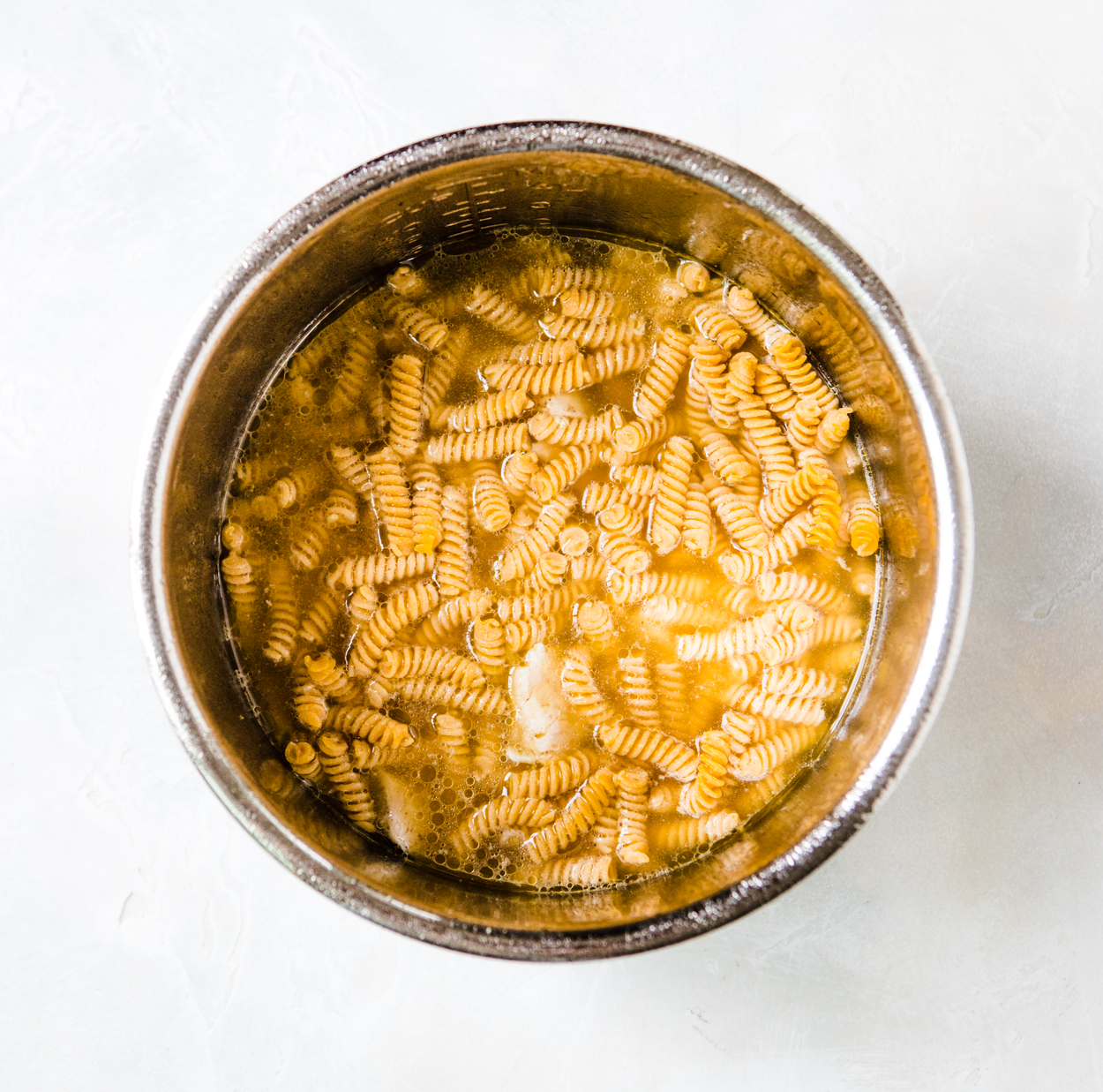 rotini pasta and chicken in chicken broth in the Instant Pot for Chicken Alfredo