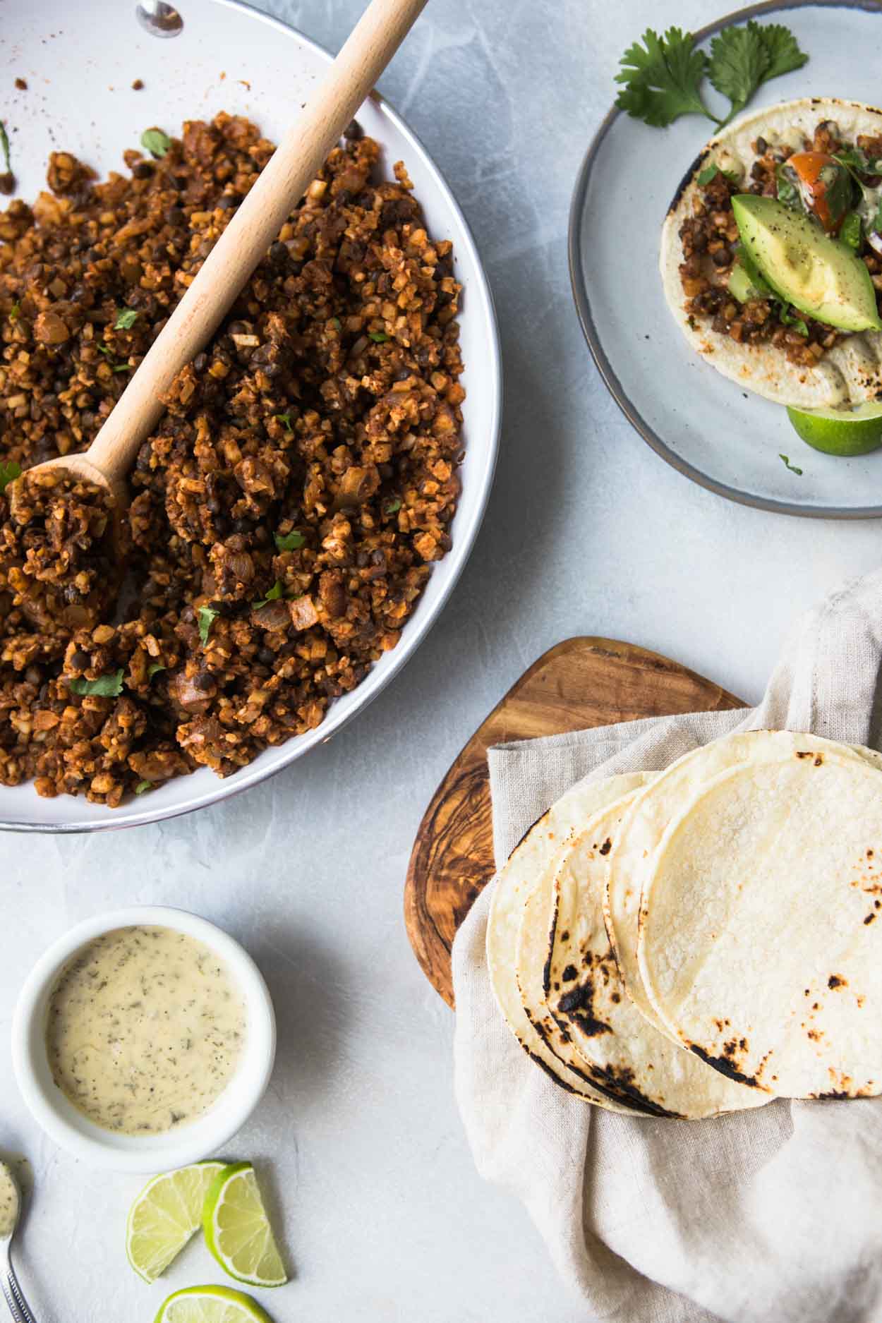 Ingredients for vegan cauliflower and lentil tacos on a white board with tortillas 