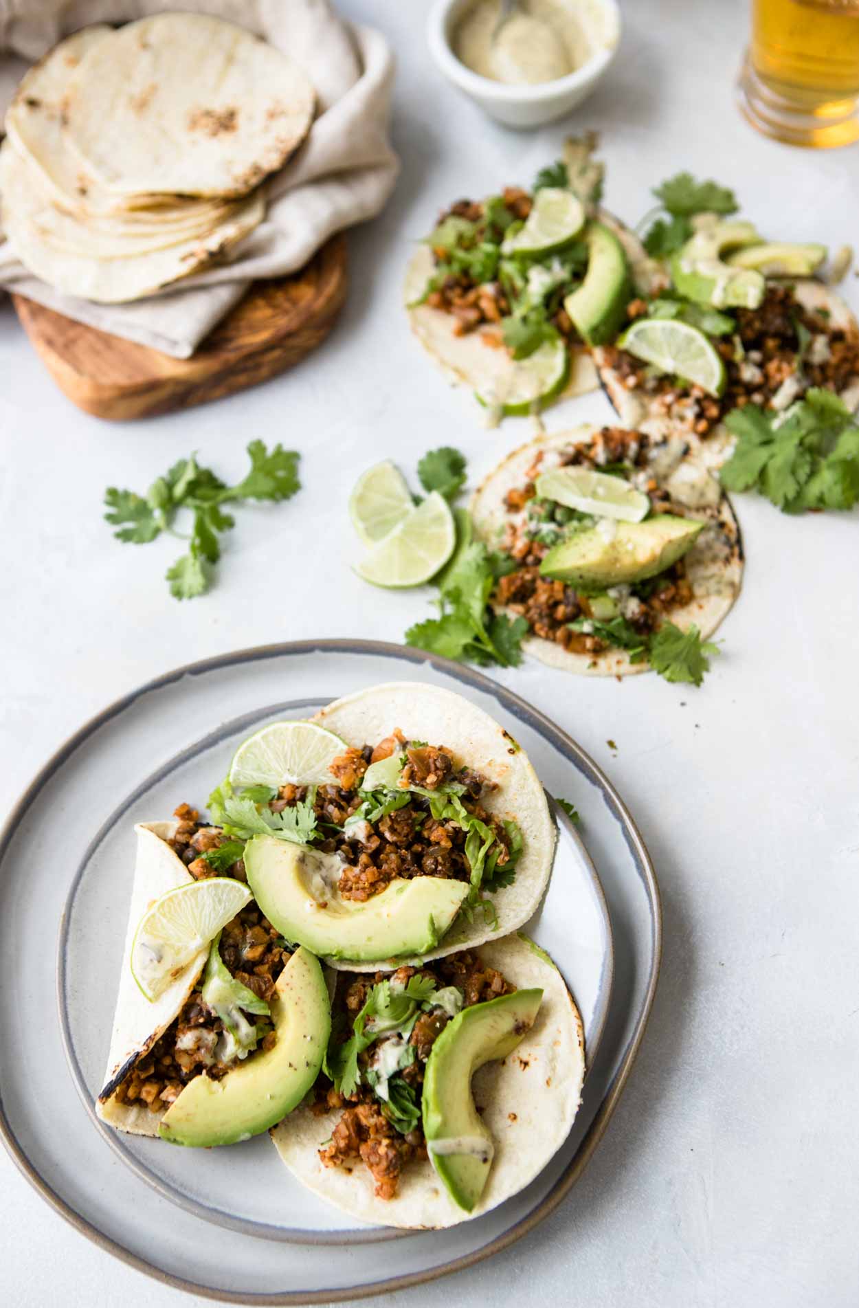 Cauliflower rice tacos with lentils on flour tortillas with cilantro, avocado and limes
