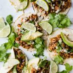 Cauliflower rice tacos on flour tortillas with cilantro, avocado and limes