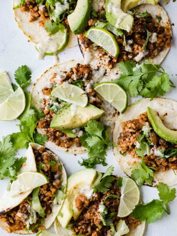 Cauliflower rice tacos on flour tortillas with cilantro, avocado and limes