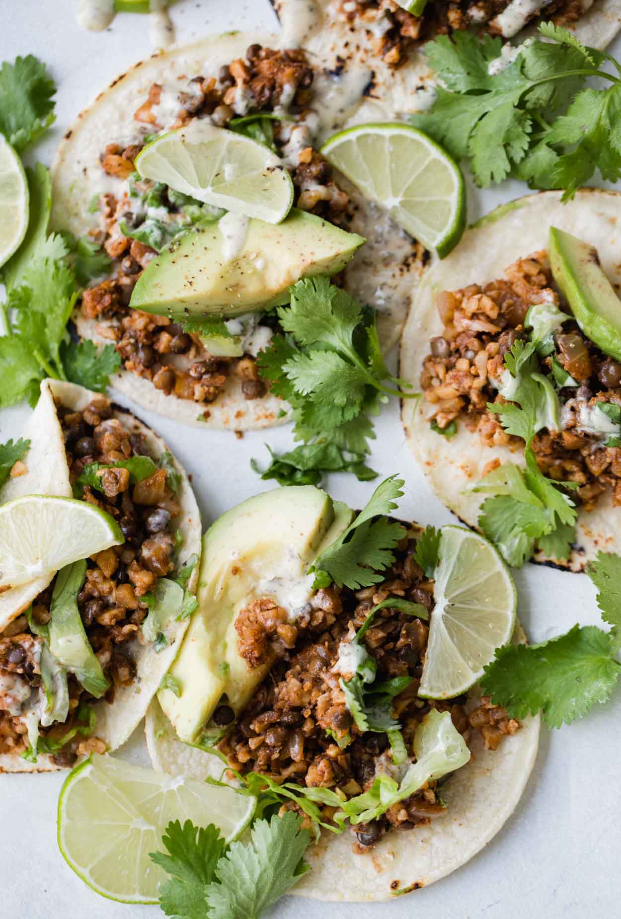 Close up of vegetarian lentil tacos with lime and cilantro garnishes