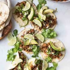 Cauliflower rice tacos on flour tortillas with cilantro, avocado and limes