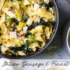 Wide egg noodles with sausage, kale and fennel in a black cast iron pot on a gray surface