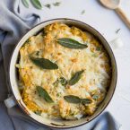Stuffed pasta shells in a cream colored bowl on a white background