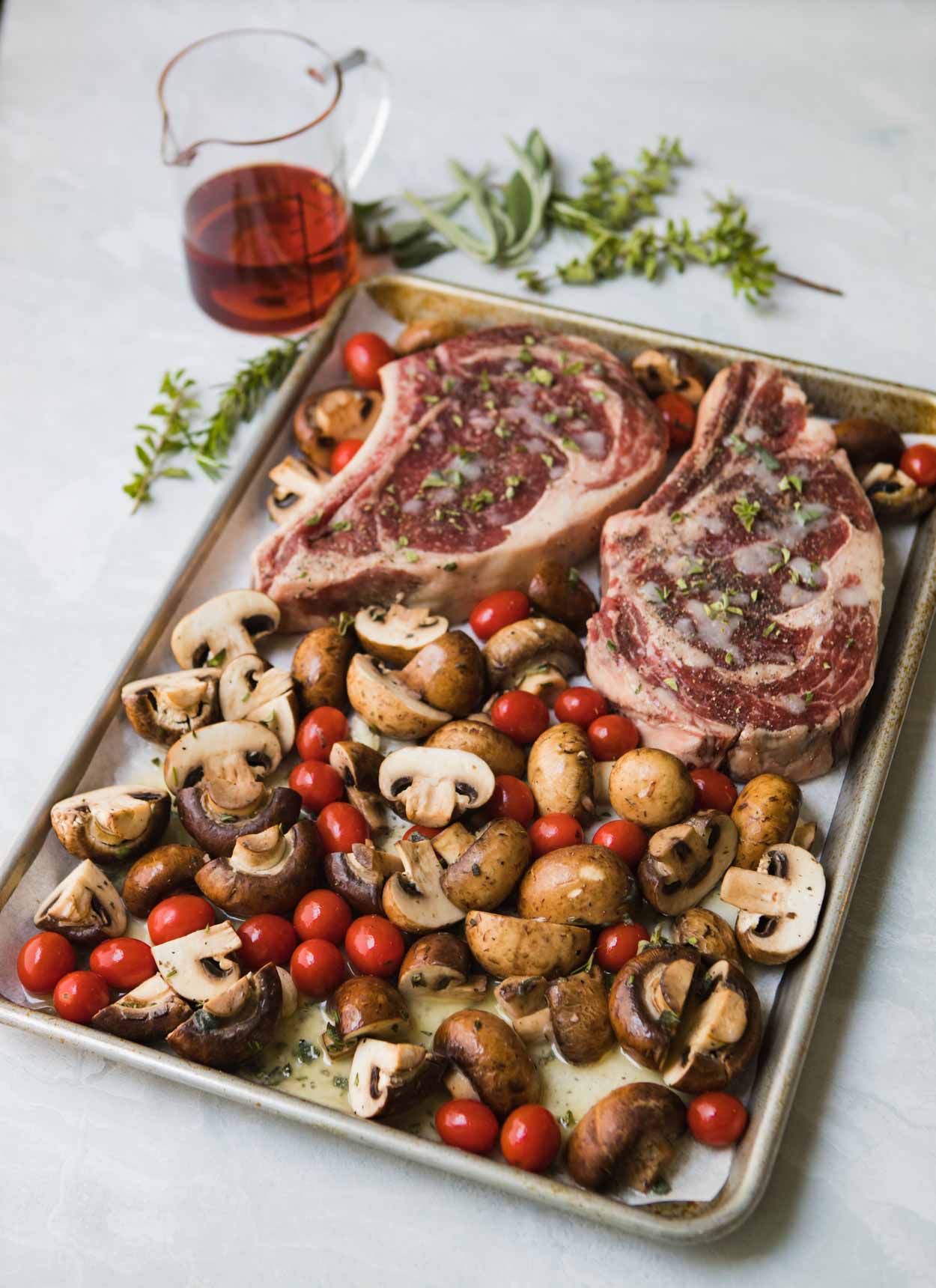 Steak, mushrooms and tomatoes on a sheet pan with fresh herbs and Marsala wine 