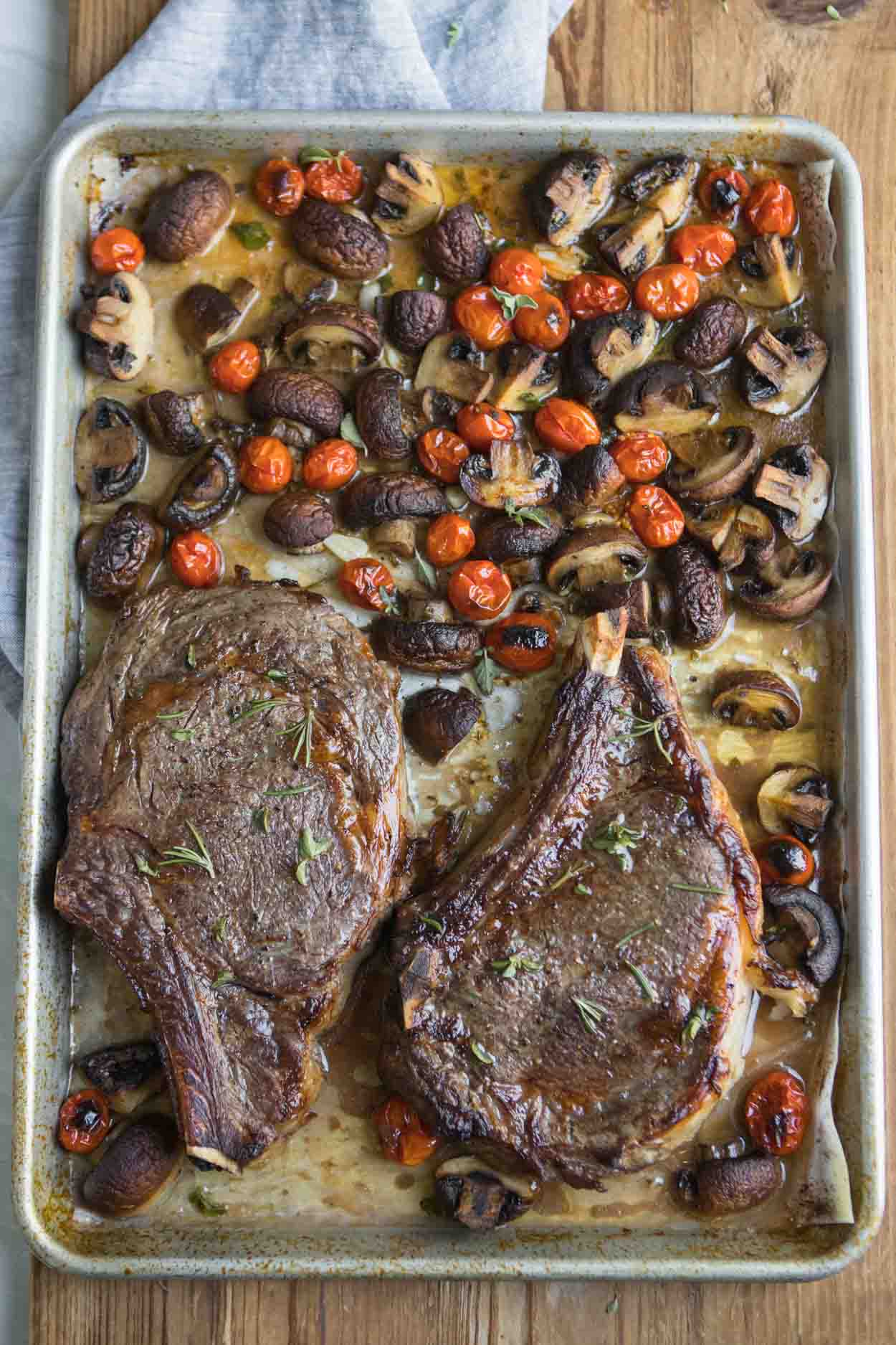 Steak, mushrooms and tomatoes on a sheet pan with fresh herbs and Marsala wine